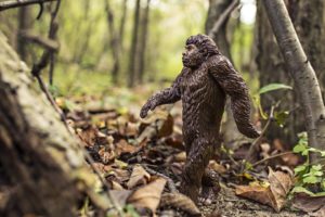 A Bigfoot figurine in the forest.