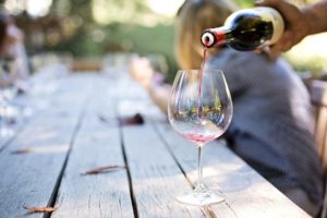 A glass of wine on a picnic table.